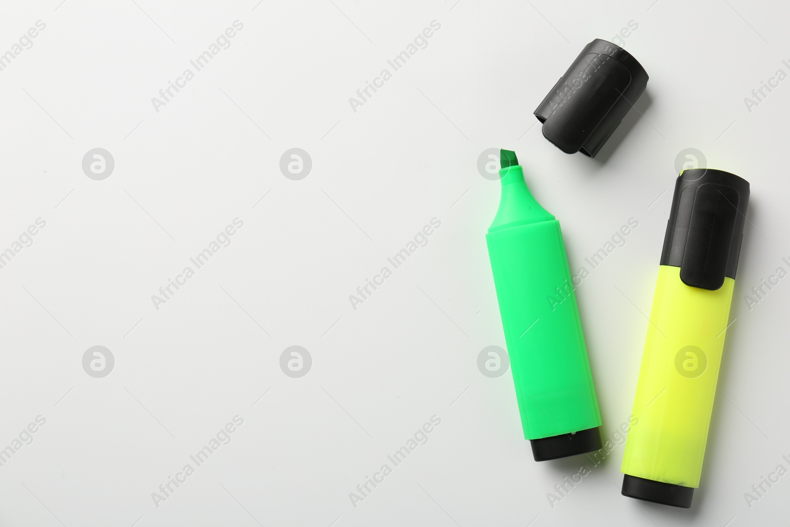 Photo of Bright highlighters on white background, flat lay. Space for text