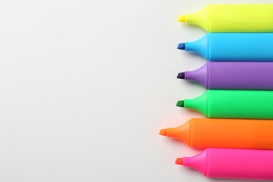 Photo of Bright highlighters on white background, flat lay. Space for text