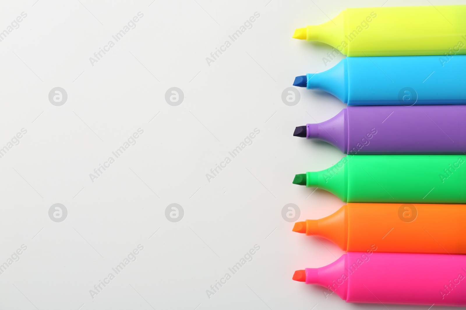 Photo of Bright highlighters on white background, flat lay. Space for text