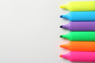 Photo of Bright highlighters on white background, flat lay. Space for text