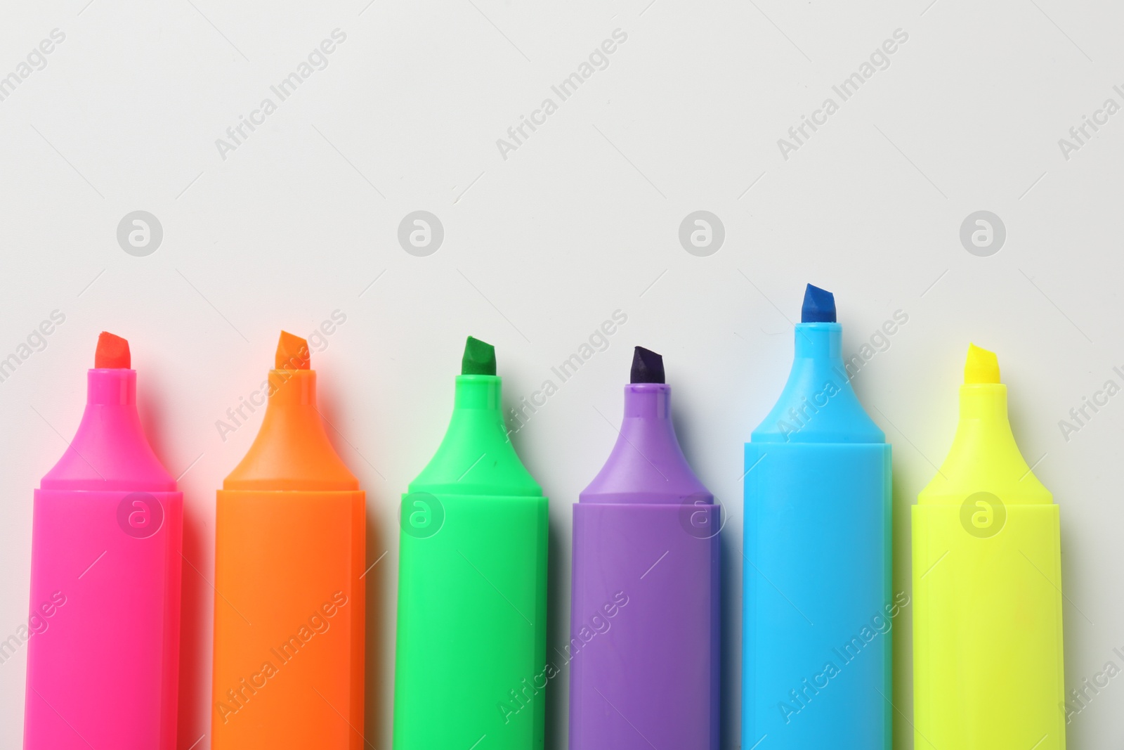 Photo of Bright highlighters on white background, flat lay. Space for text