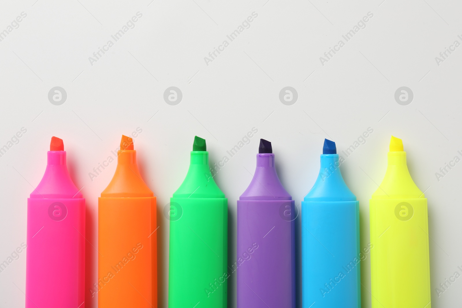 Photo of Bright highlighters on white background, flat lay. Space for text