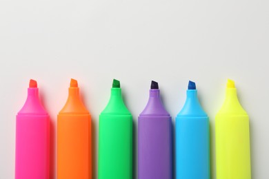 Photo of Bright highlighters on white background, flat lay. Space for text