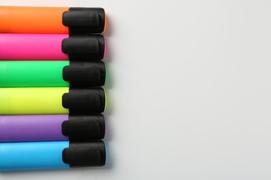 Photo of Bright highlighters on white background, flat lay. Space for text