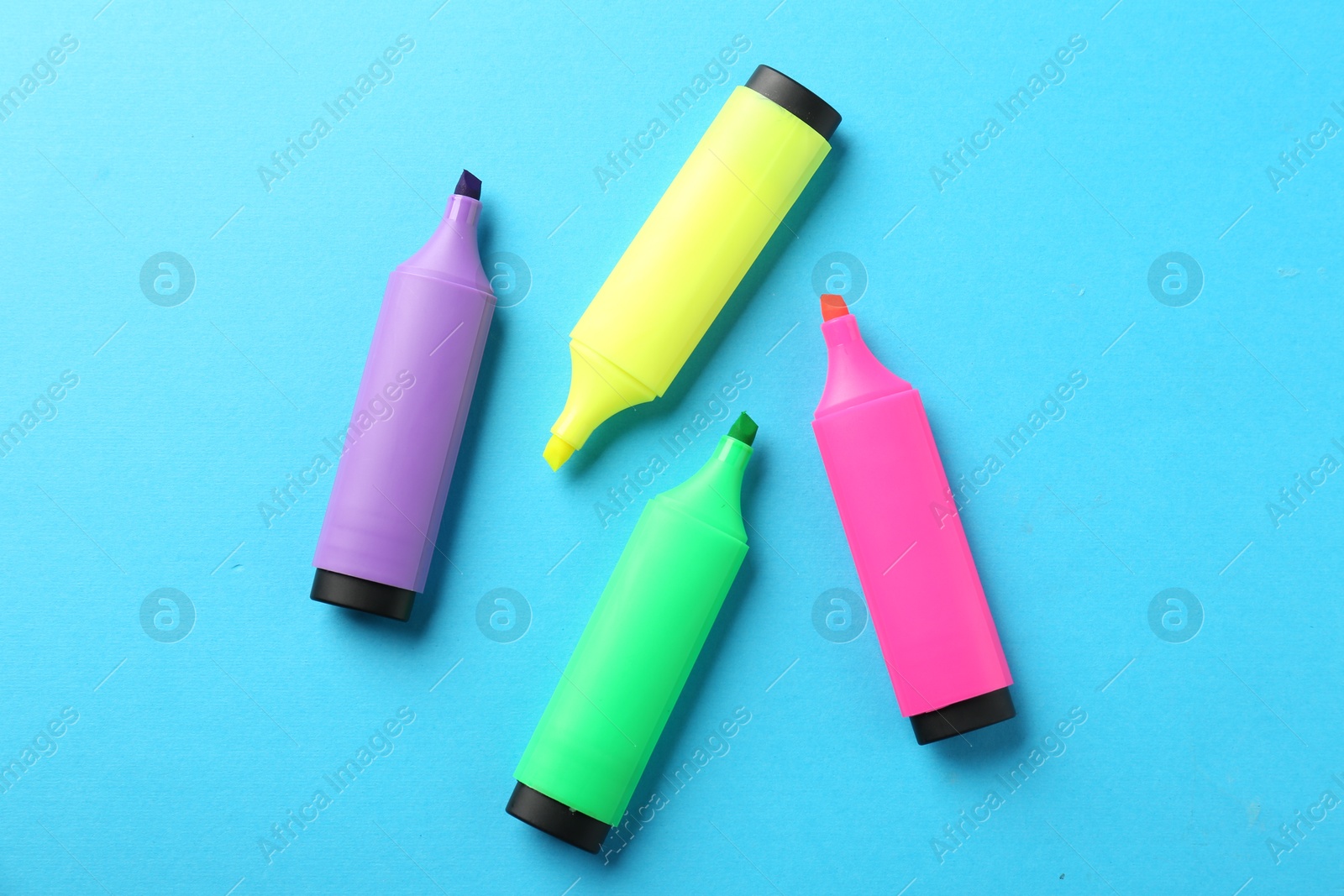 Photo of Bright highlighters on light blue background, flat lay