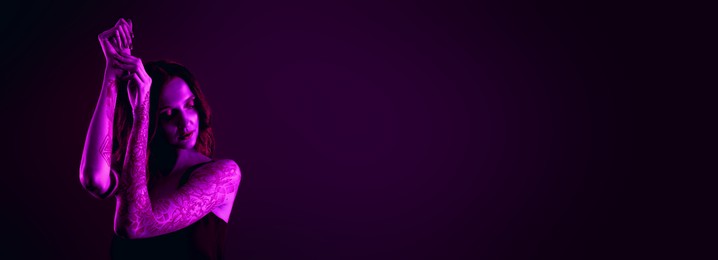 Image of Beautiful woman with tattoos on arms in neon light, space for text. Banner design