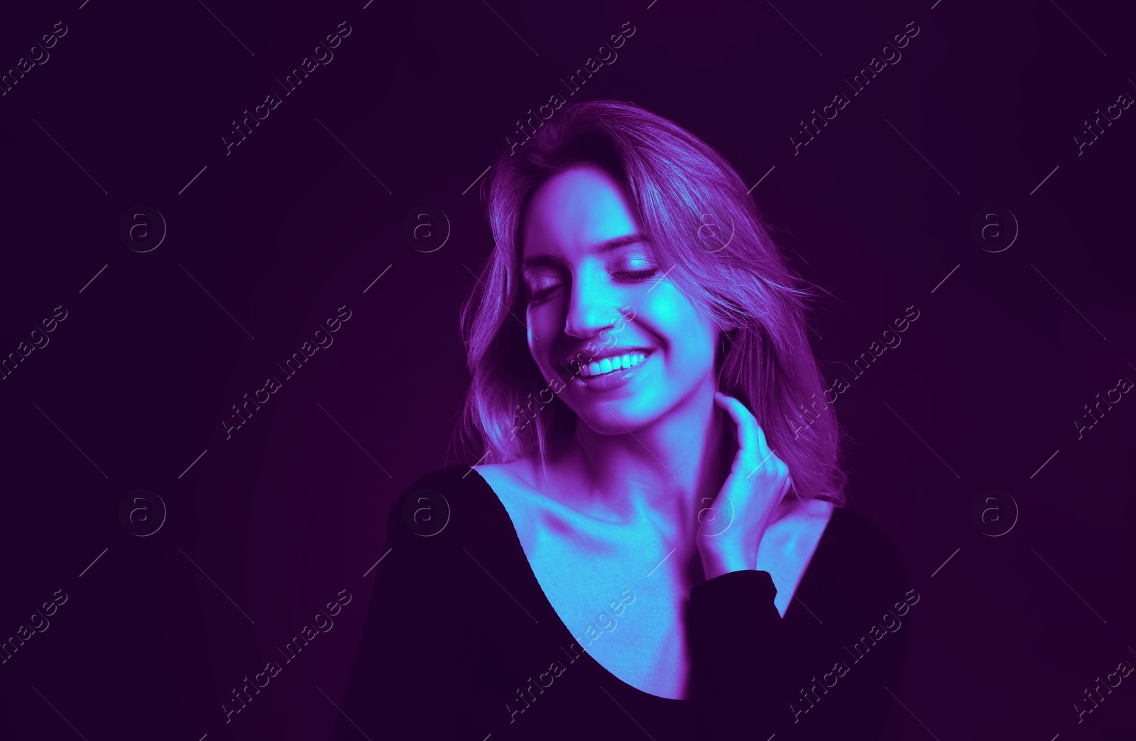 Image of Happy young woman in neon light, space for text