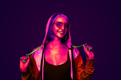 Image of Beautiful young woman with bright dyed hair in neon light