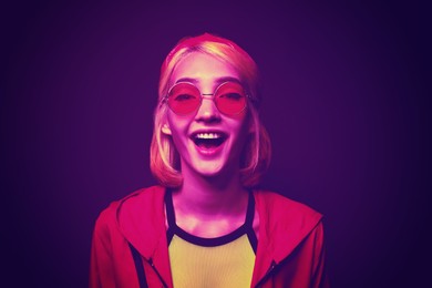 Image of Beautiful young woman with bright dyed hair in neon light