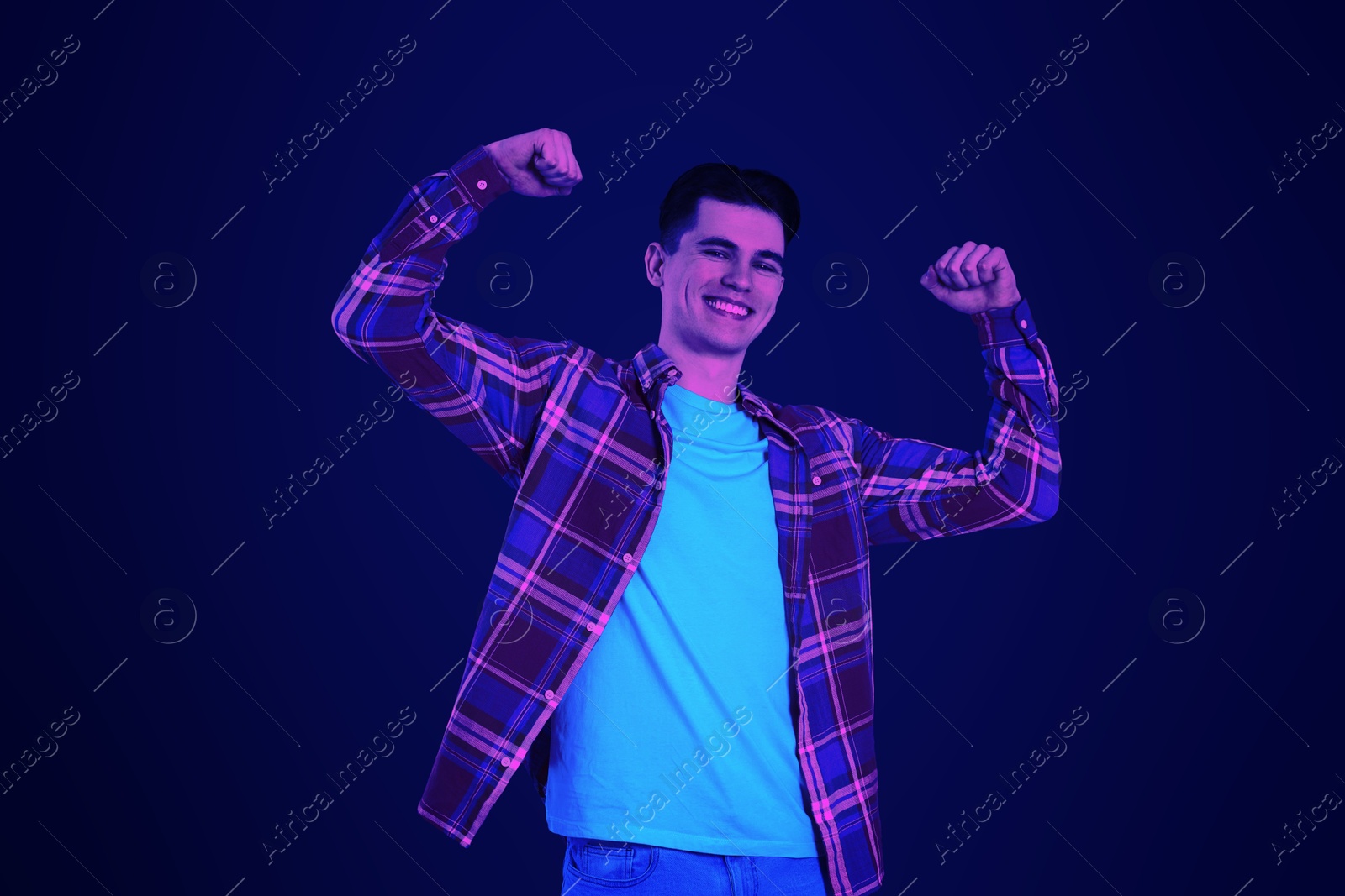 Image of Happy young dancing man in neon light