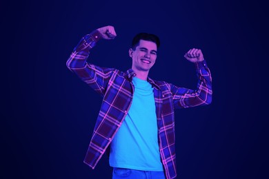 Image of Happy young dancing man in neon light