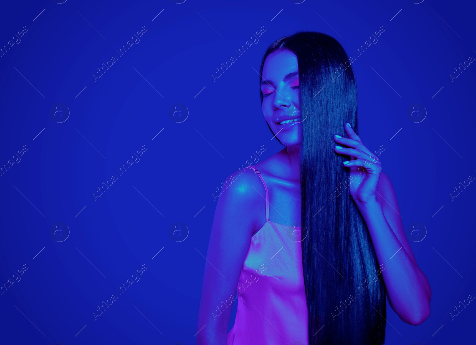 Image of Beautiful young woman in neon light, space for text