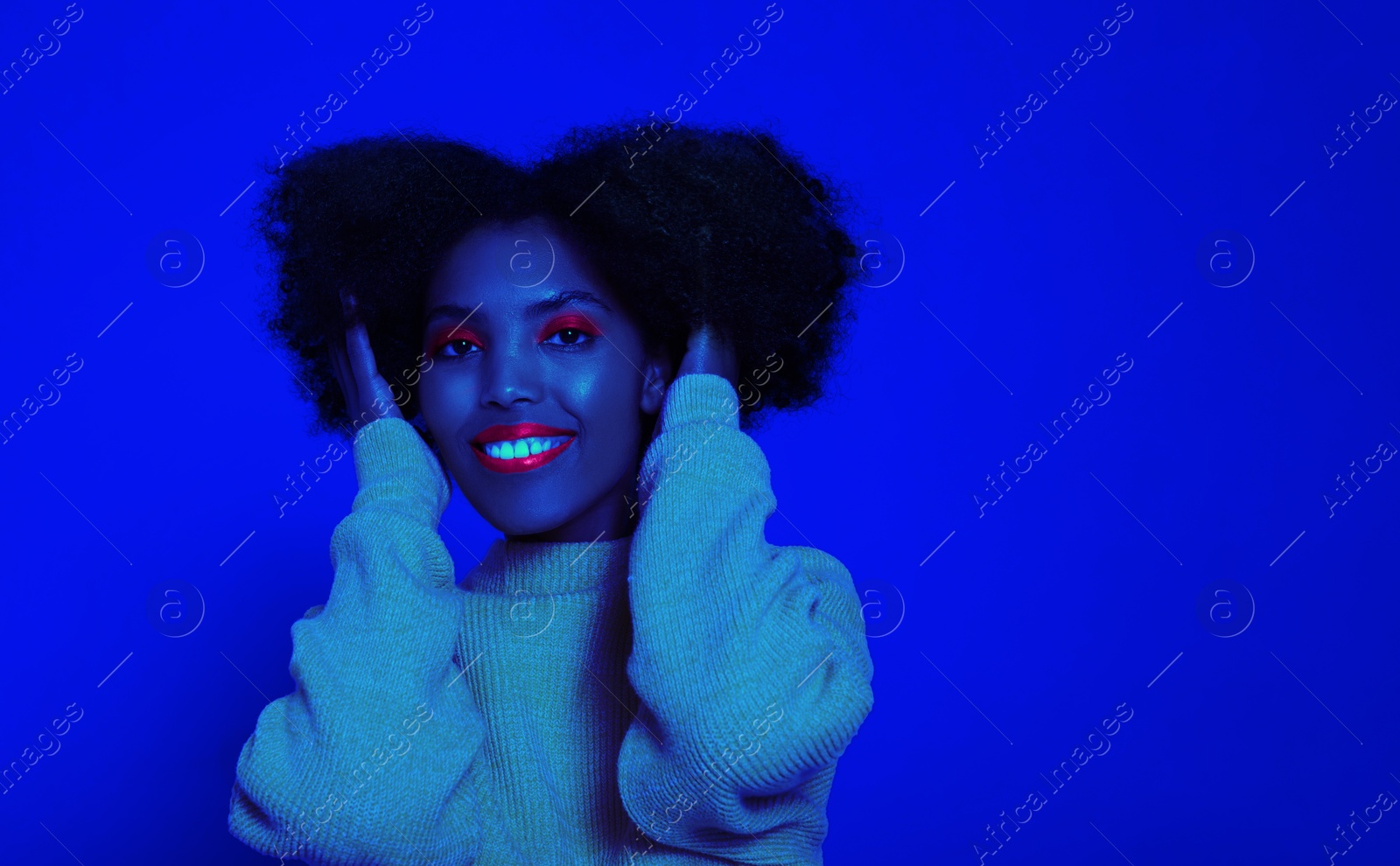 Image of Pretty woman smiling in neon light, space for text