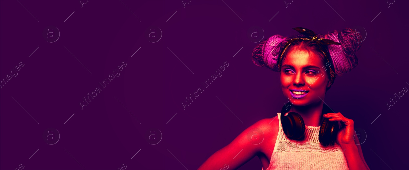 Image of Beautiful woman with braided double buns and headphones in neon light, space for text. Banner design