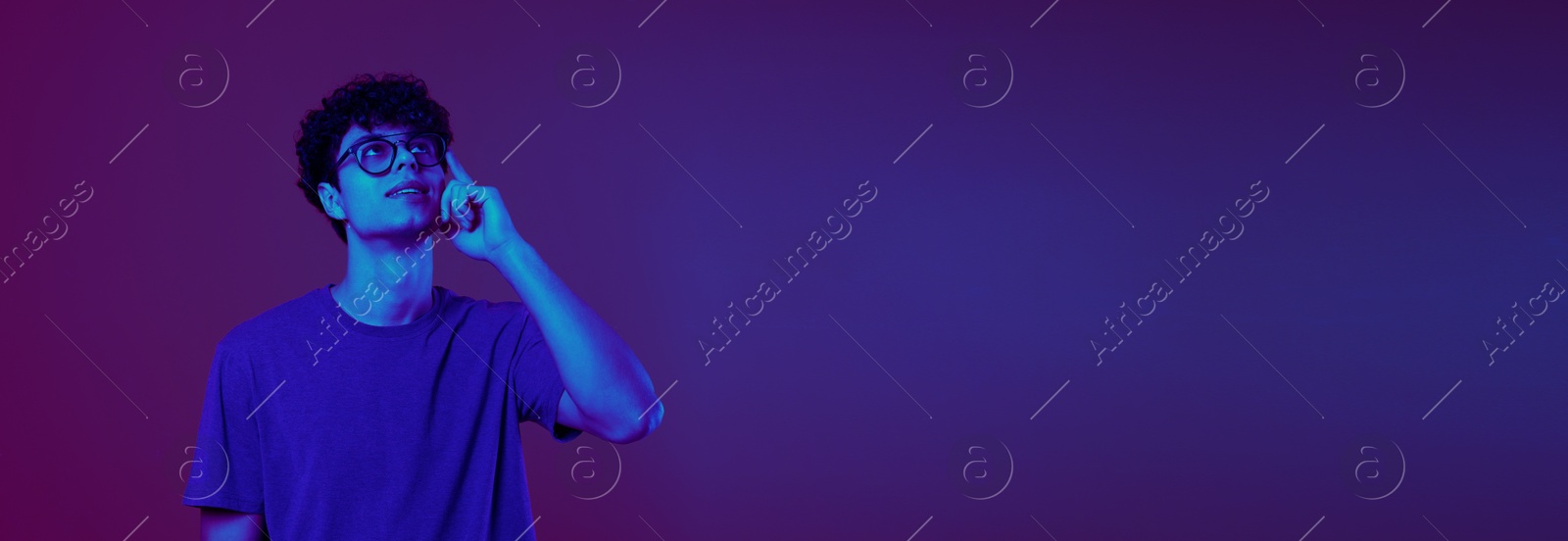 Image of Thoughtful young man in neon light, space for text. Banner design