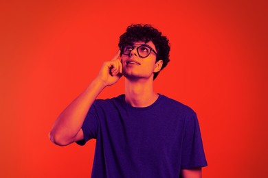 Image of Handsome thoughtful young man in neon light