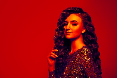 Image of Beautiful young woman with curly hair in neon light, space for text