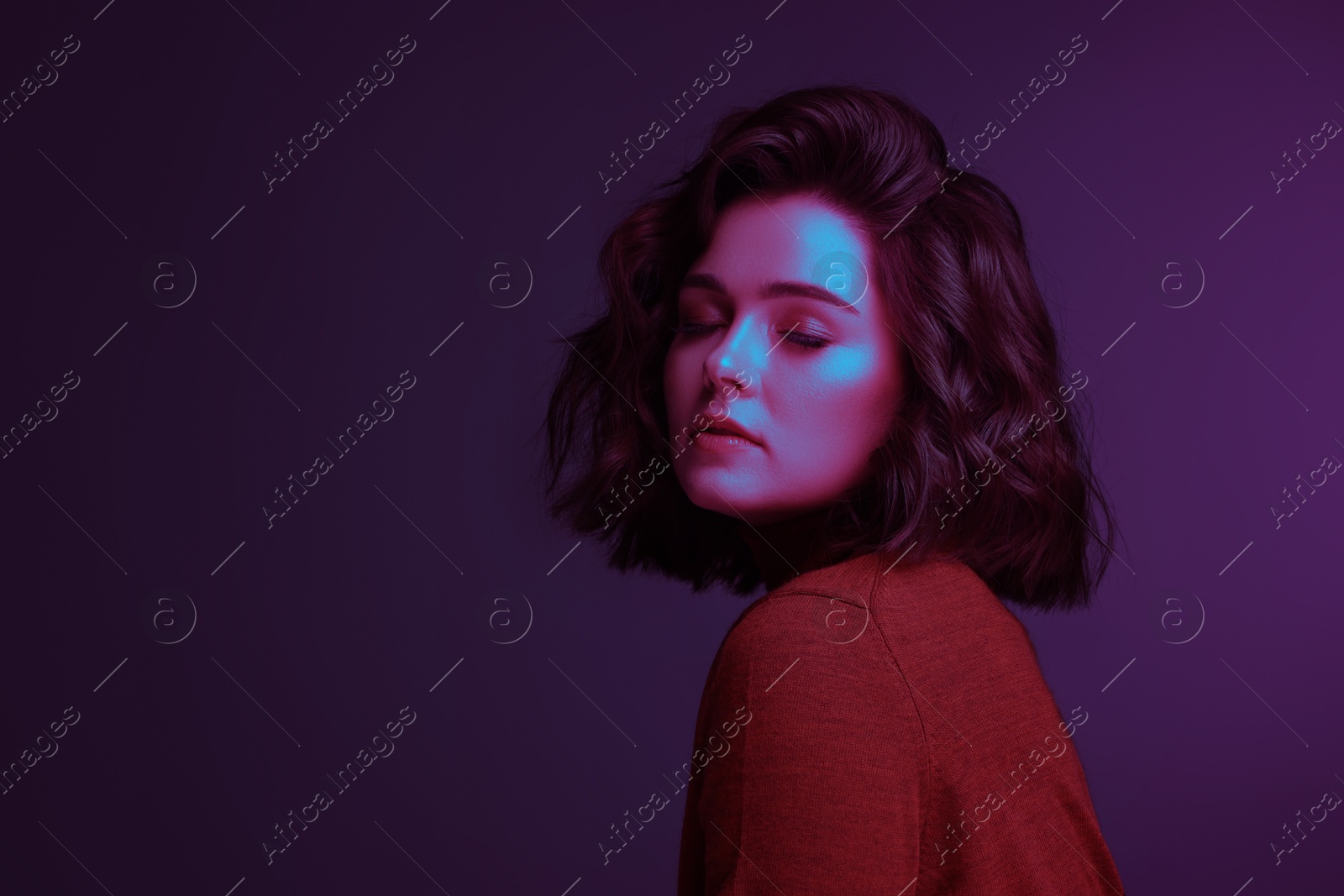 Image of beautiful young woman with wavy hairstyle in neon light, space for text