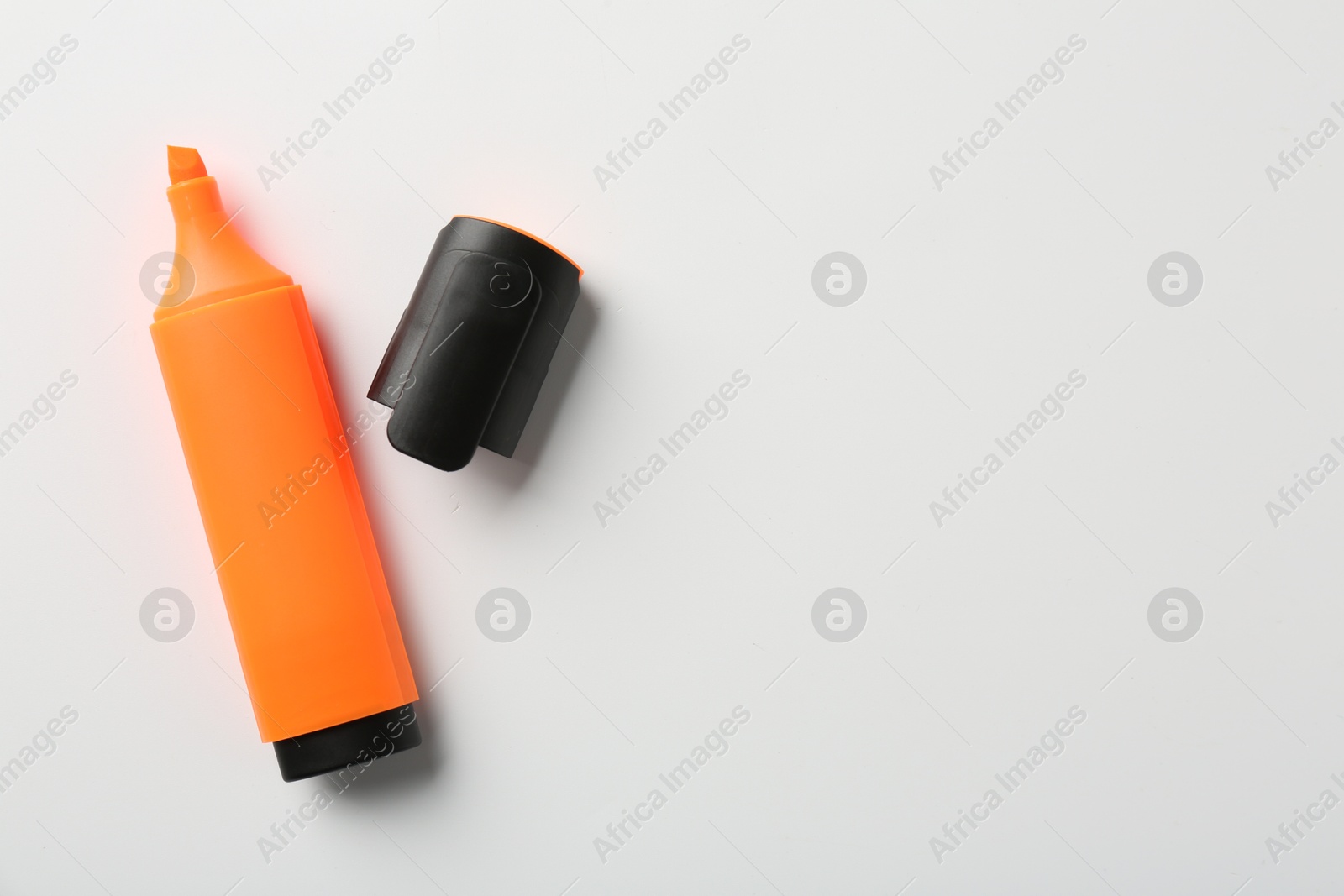 Photo of Bright highlighter and cap on white background, flat lay. Space for text