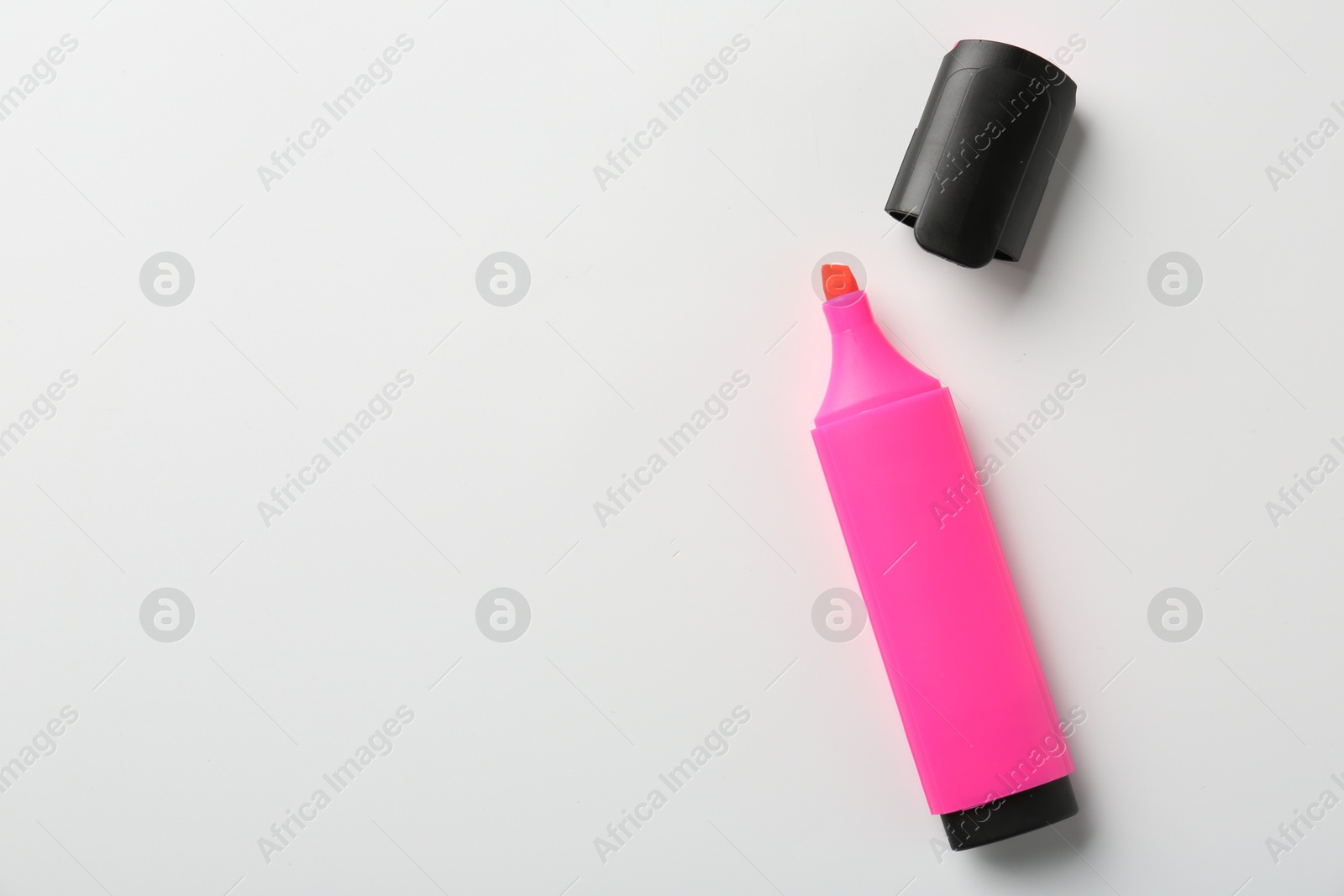 Photo of Bright highlighter and cap on white background, flat lay. Space for text