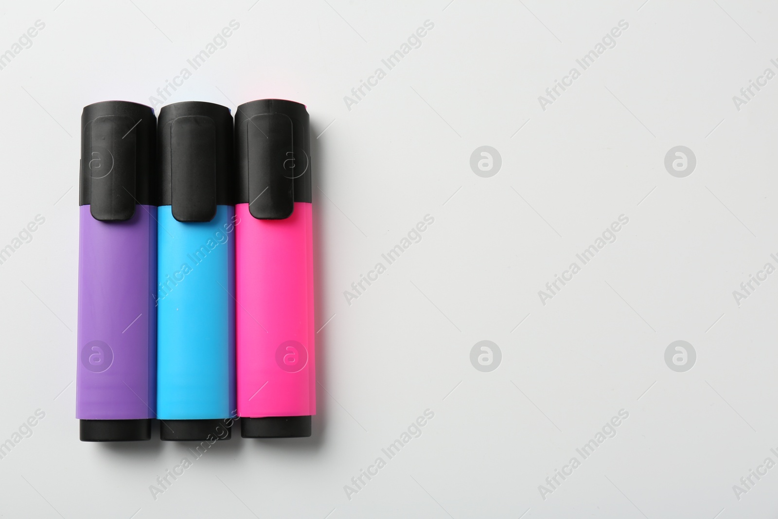 Photo of Bright highlighters on white background, flat lay. Space for text