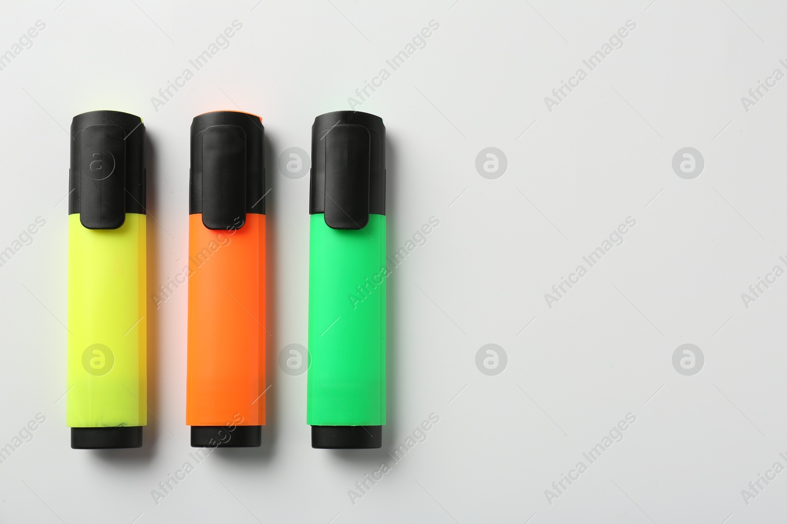 Photo of Bright highlighters on white background, flat lay. Space for text