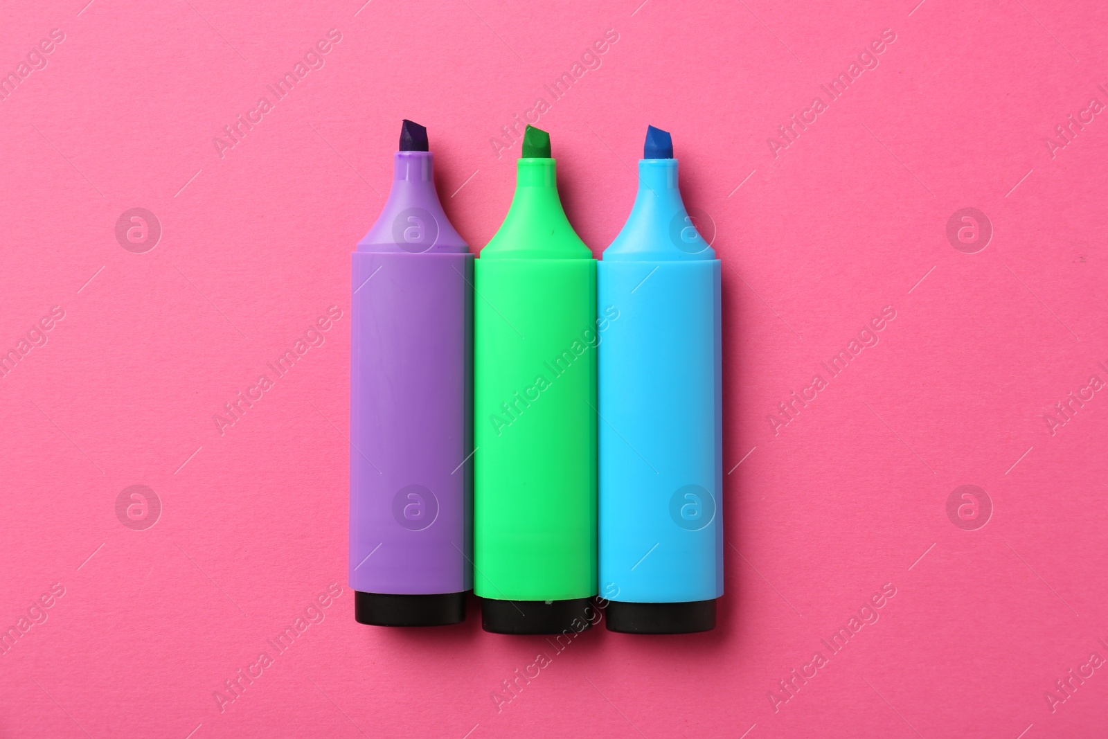 Photo of Bright highlighters on pink background, flat lay