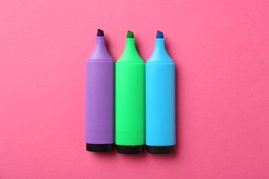 Photo of Bright highlighters on pink background, flat lay