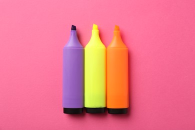 Photo of Bright highlighters on pink background, flat lay