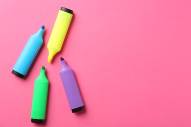 Photo of Bright highlighters on pink background, flat lay. Space for text