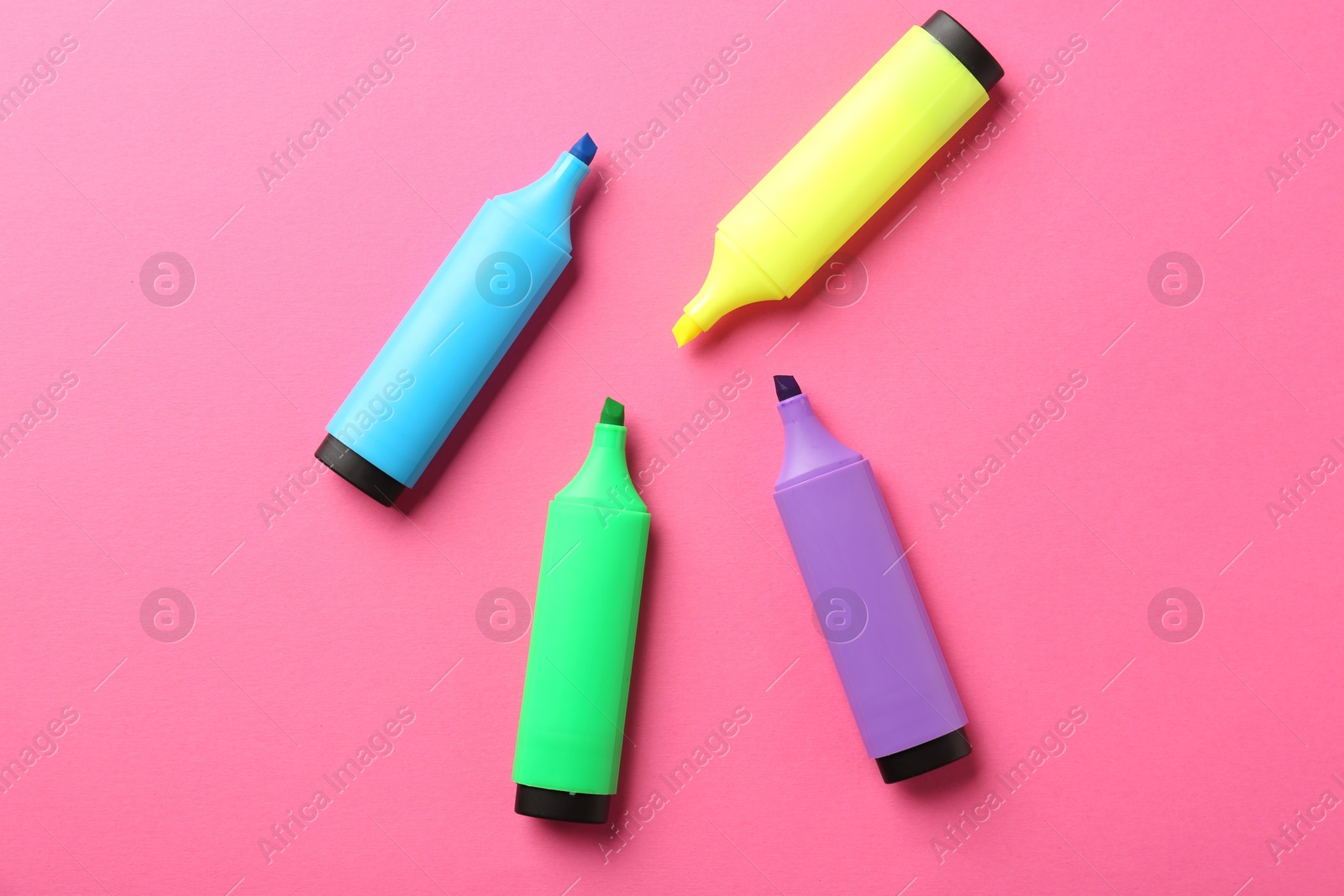 Photo of Bright highlighters on pink background, flat lay