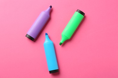 Photo of Bright highlighters on pink background, flat lay