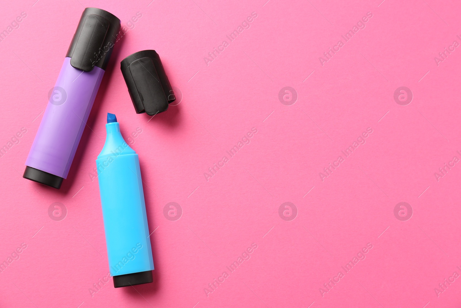 Photo of Bright highlighters on pink background, flat lay. Space for text