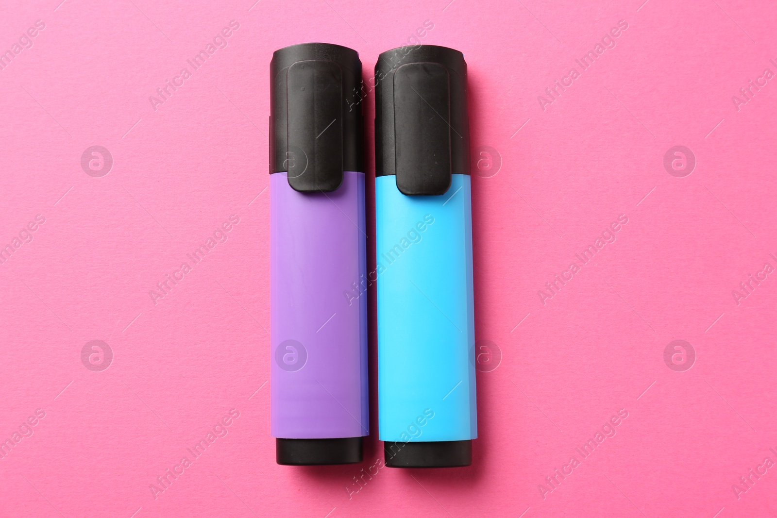 Photo of Bright highlighters on pink background, flat lay