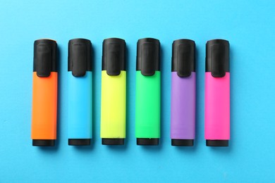 Photo of Bright highlighters on light blue background, flat lay