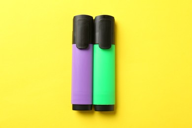 Photo of Bright highlighters on yellow background, flat lay