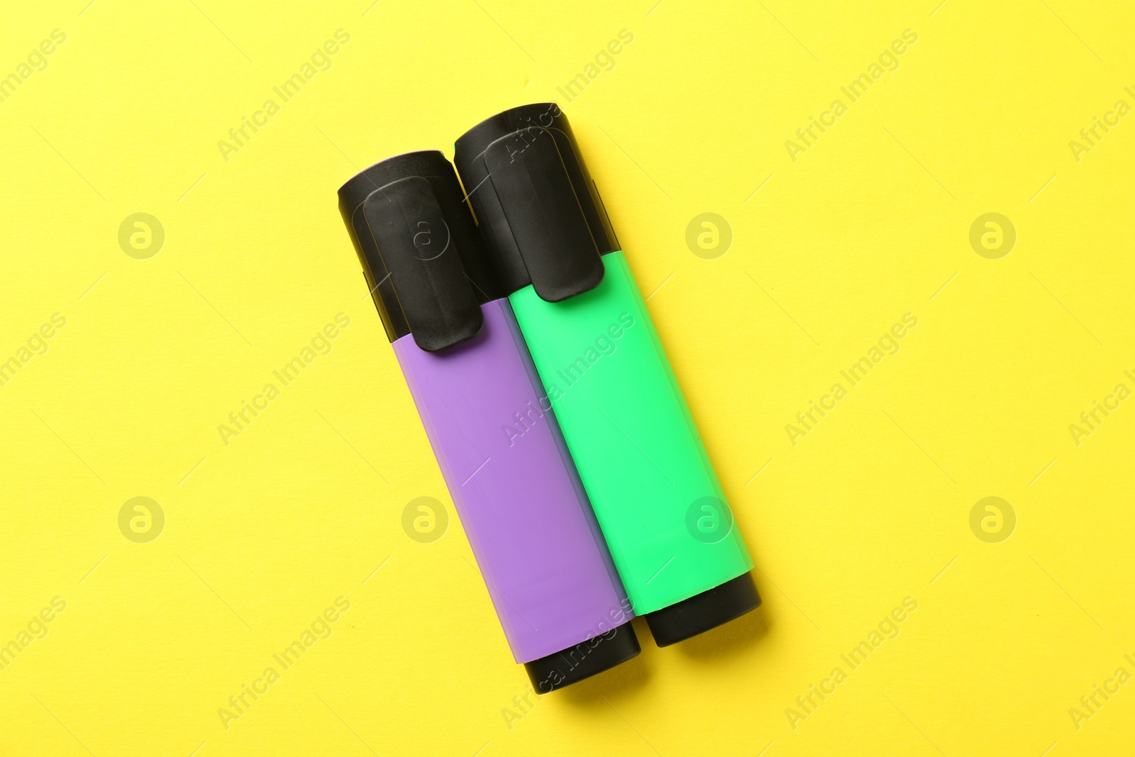 Photo of Bright highlighters on yellow background, flat lay