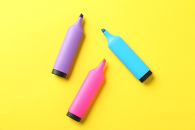 Photo of Bright highlighters on yellow background, flat lay