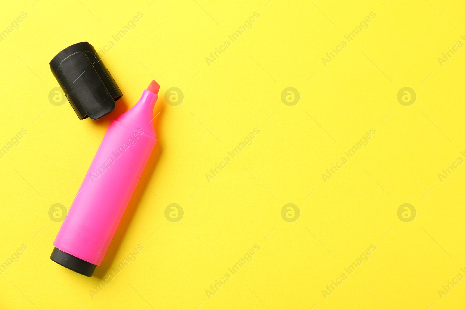 Photo of Bright highlighter and cap on yellow background, flat lay. Space for text