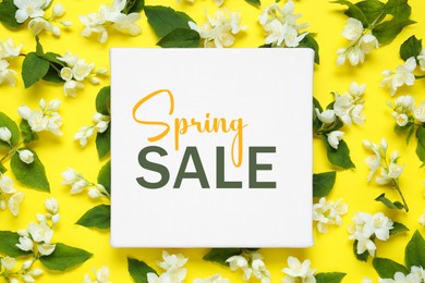 Image of Spring Sale card and jasmine flowers on yellow background, top view. Seasonal discount