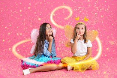 Image of Cute girls with fairy wings on pink background. Magic lights around