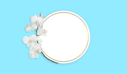 Image of Empty card and orchid flowers on light blue background, top view. Banner design