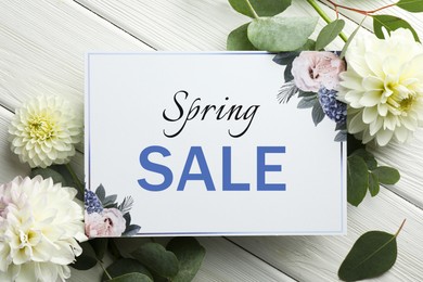 Image of Spring Sale card and beautiful flowers on white wooden background, top view. Seasonal discount