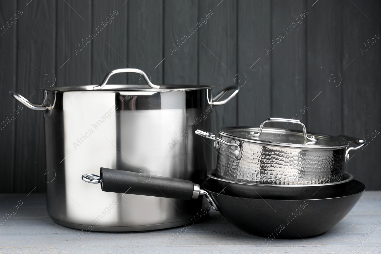 Photo of Stainless steel dishware on grey wooden table