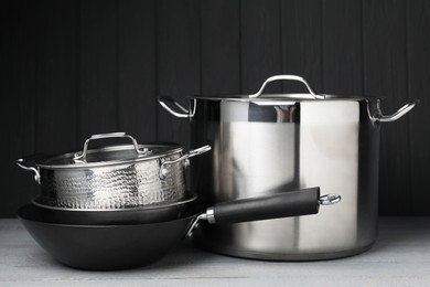 Photo of Stainless steel dishware on grey wooden table