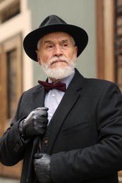 Photo of Portrait of elegant senior man in hat outdoors