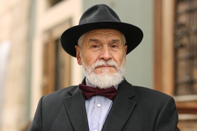 Photo of Portrait of elegant senior man in hat outdoors