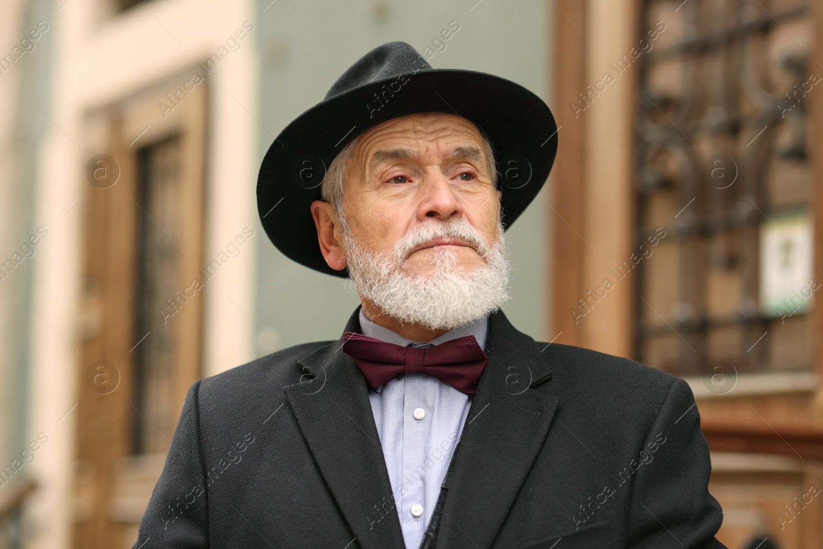 Photo of Portrait of elegant senior man in hat outdoors