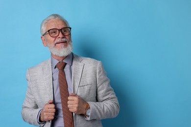 Photo of Portrait of senior man with gray beard on light blue background. Space for text