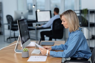 Photo of Technician making digital engineering drawing on computer at desk in office